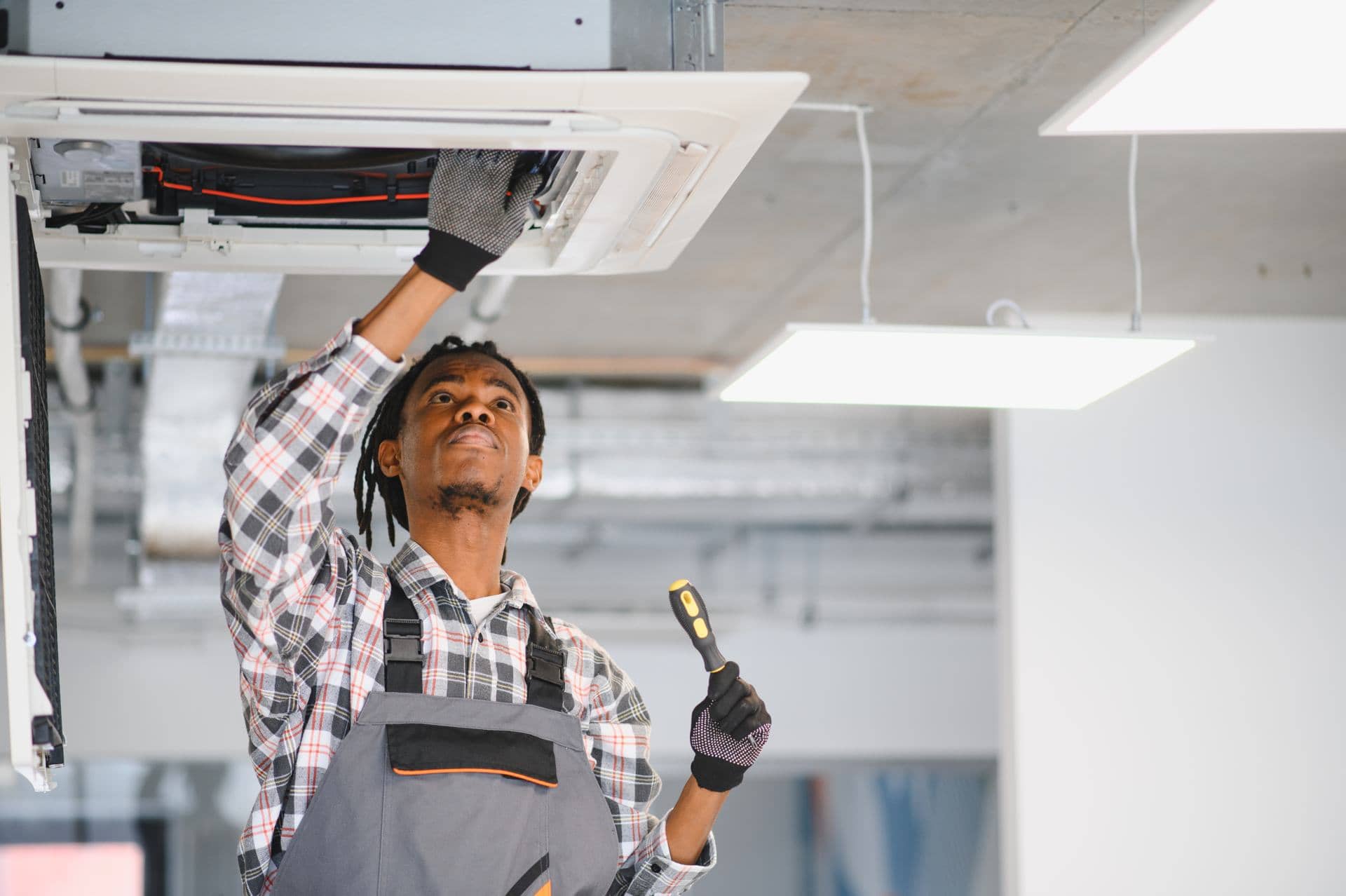 Maintenance technician servicing an air conditioning unit in a Dubai office