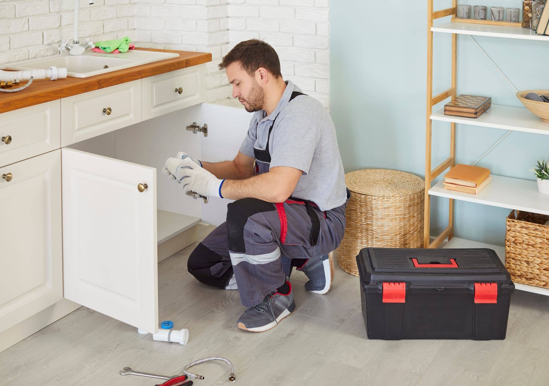 Plumber clearing a blocked kitchen sink drain in a Dubai home