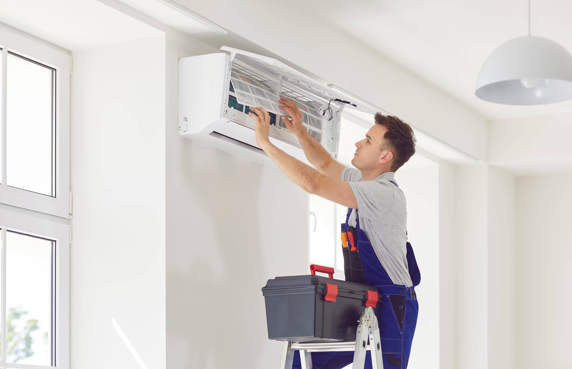 Technician installing a split air conditioner on a wall in Dubai