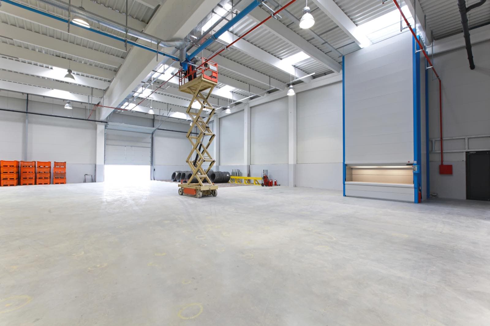 Industrial Handover Repaint in Dubai: Empty industrial unit with a scissor lift and clean walls ready for handover