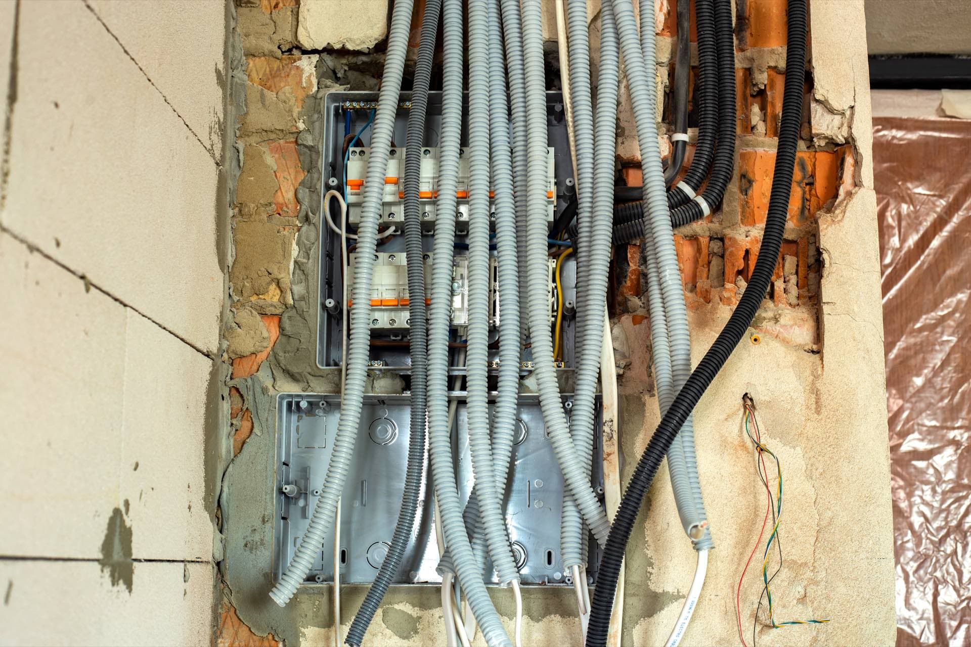 Home Rewiring in Dubai: Electrical cables in protective conduit running through an opened wall