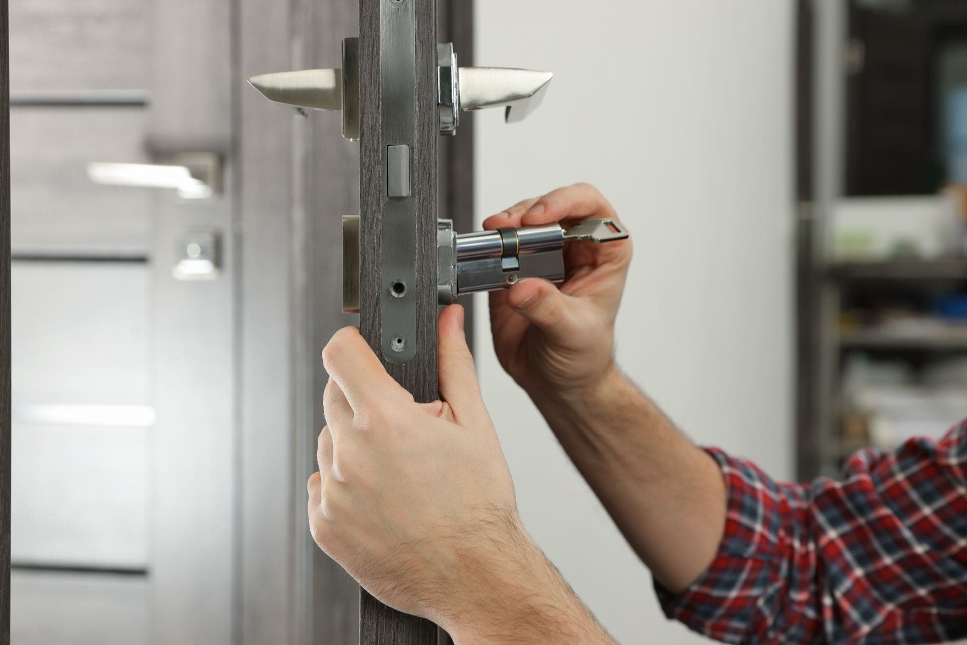 Lock Replacement in Dubai: Hands fitting a new cylinder into a door lock