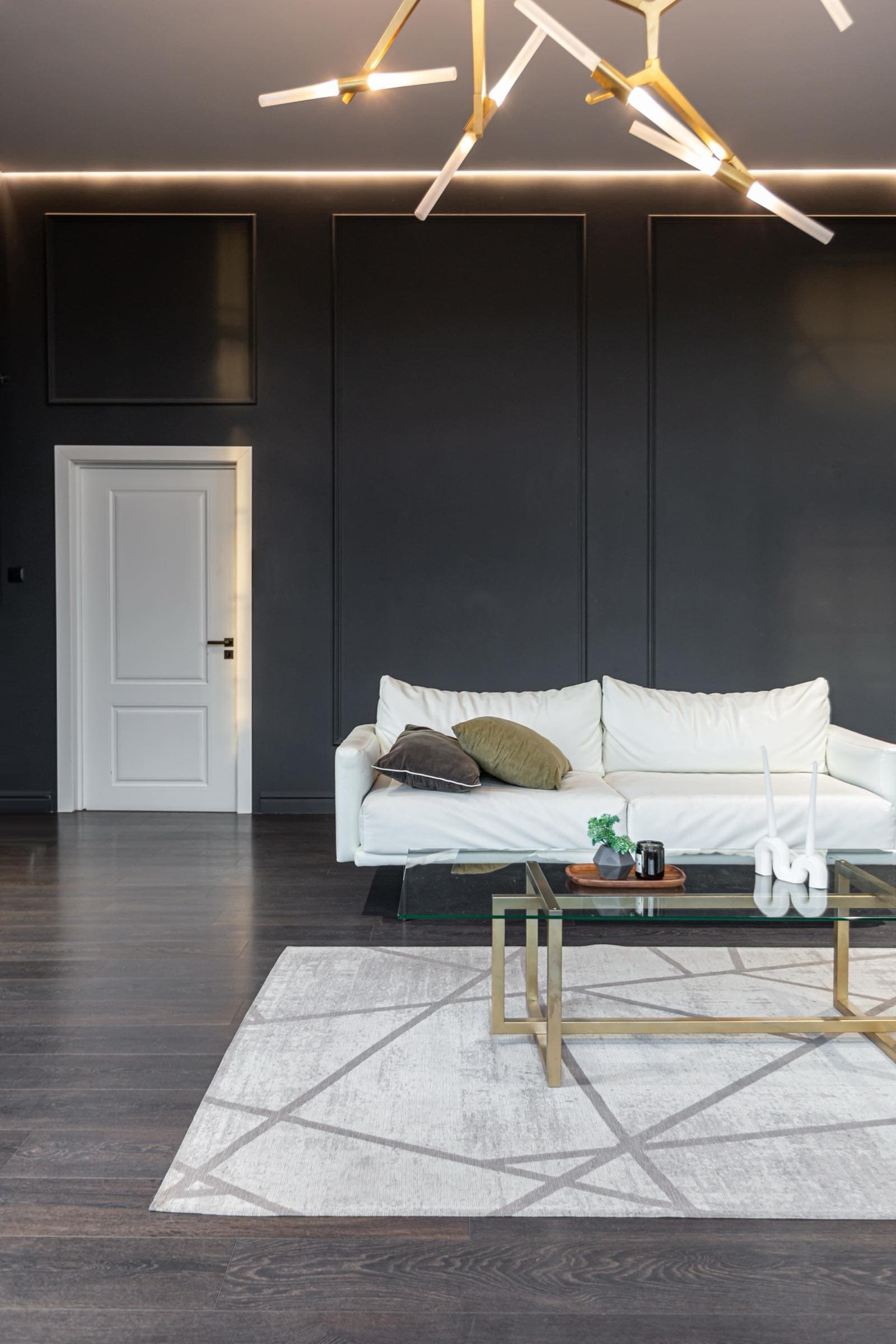 Feature Wall Painting in Dubai: Living room with a dark feature wall and a white sofa