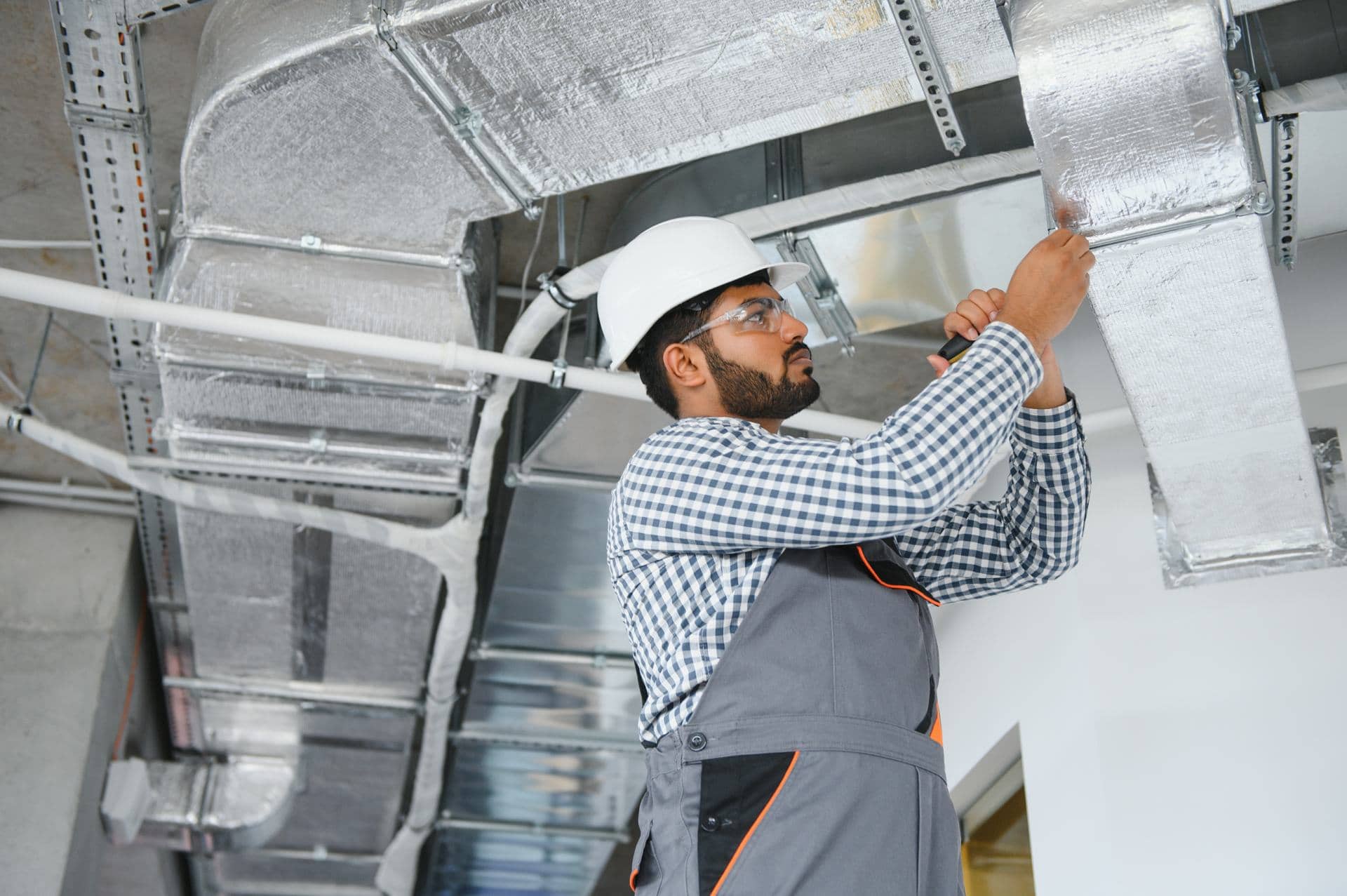 Technician cleaning and inspecting AC ductwork in a Dubai building