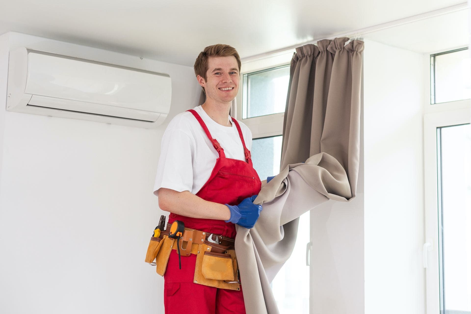 Curtain Hanging in Dubai: Technician hanging a curtain beside a window in a Dubai apartment