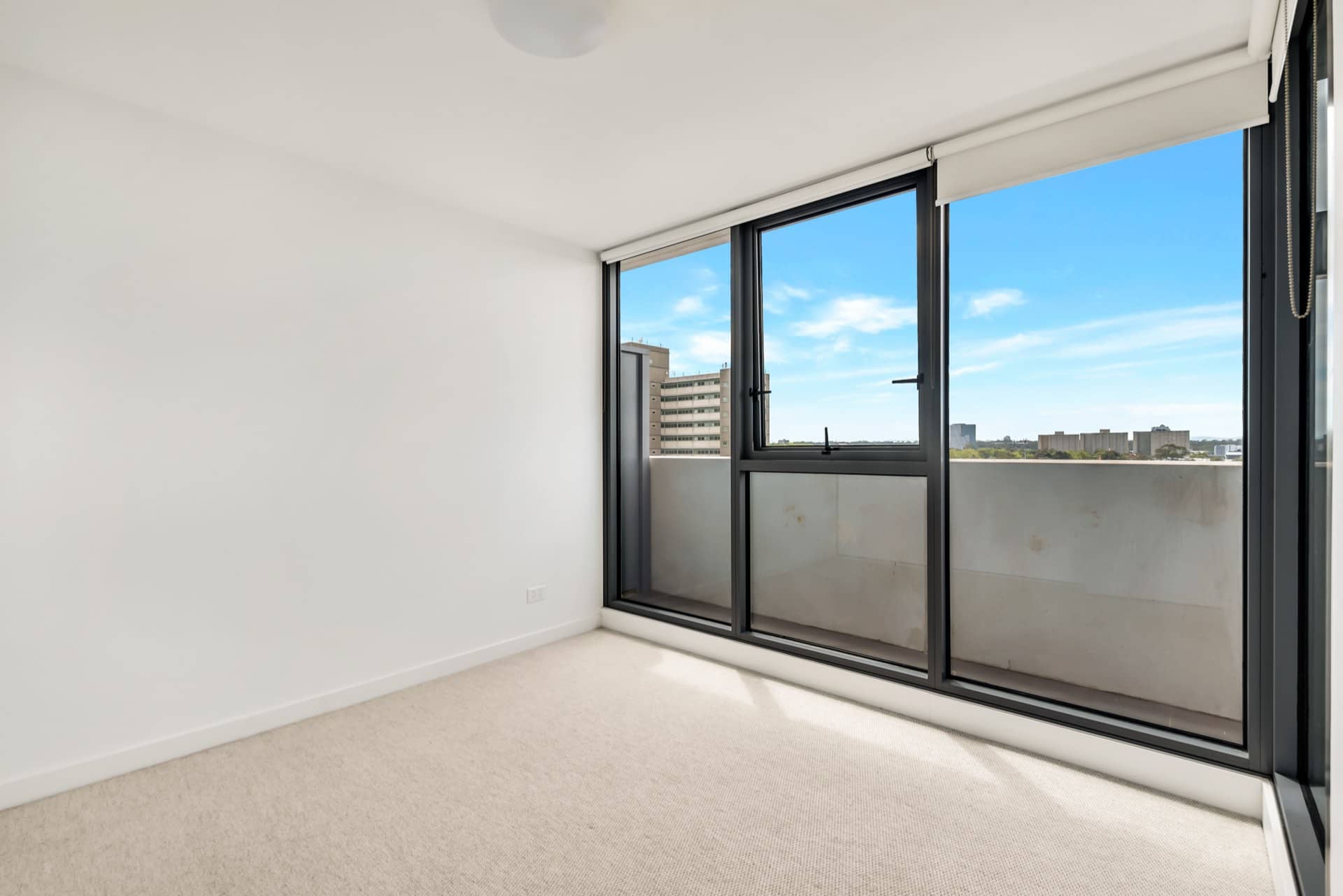 Empty apartment room with a carpet and a balcony window ready for handover