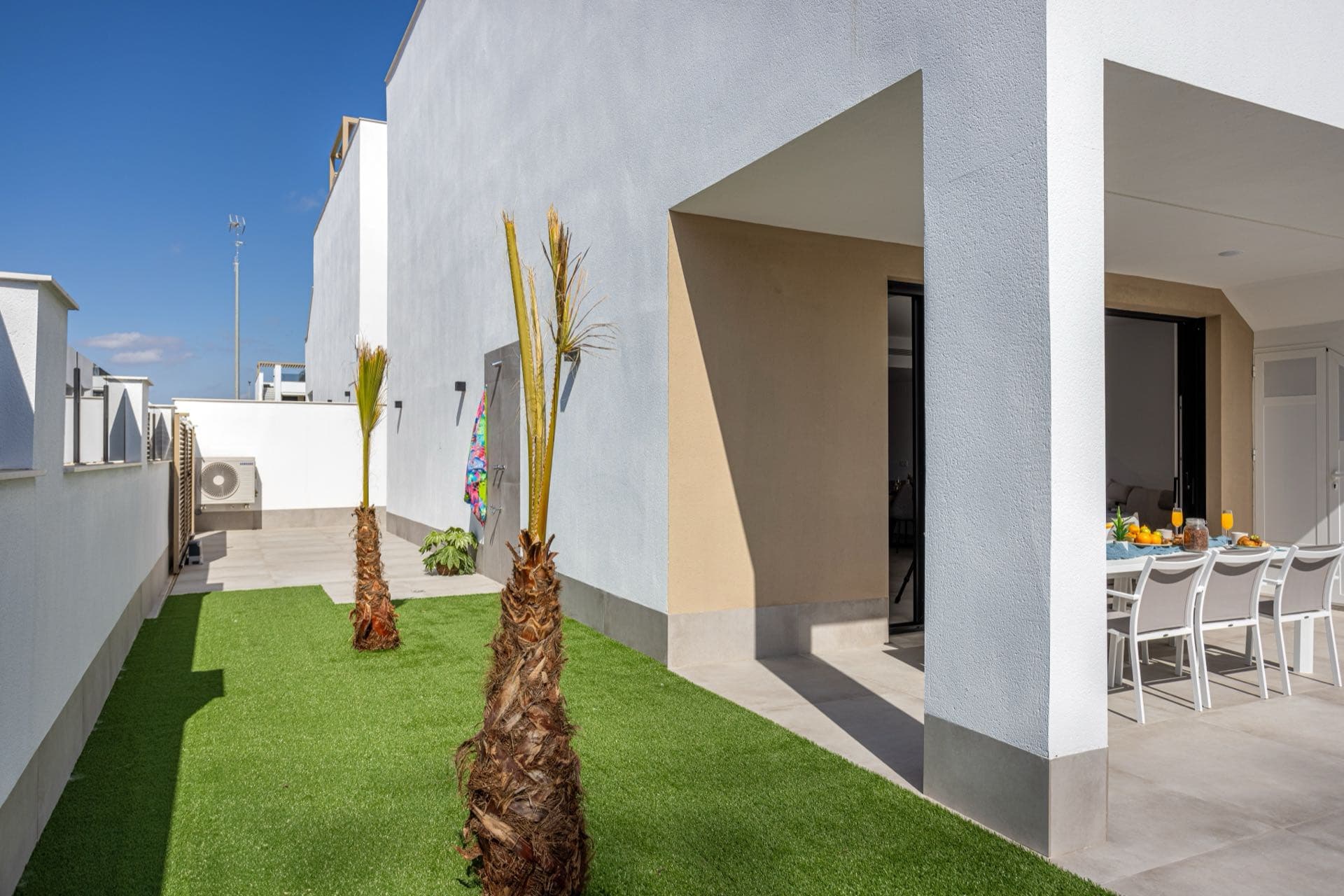 Villa and Apartment Care for Rentals in Dubai: White contemporary villa with palm trees and a lawn in Dubai
